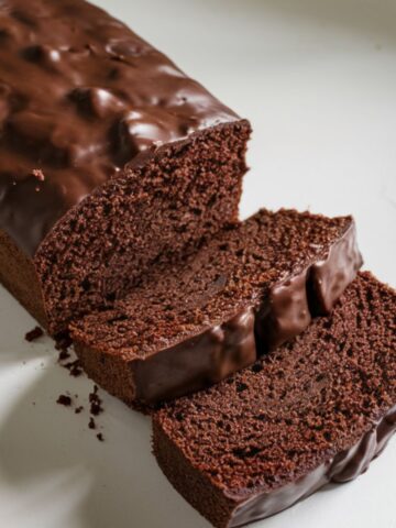 chocolate pound cake topped with shiny chocolate glaze, sliced to show its rich and moist interior