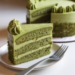 Vibrant baked matcha cake recipe vegan with green frosting and edible flowers