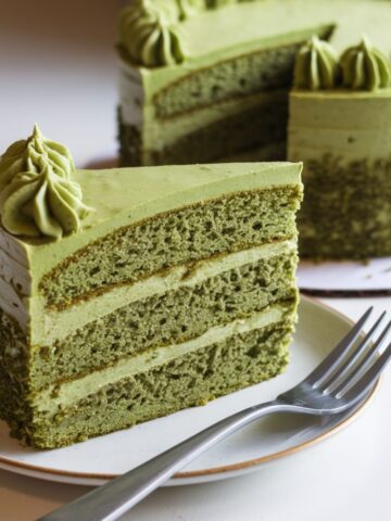 Vibrant baked matcha cake recipe vegan with green frosting and edible flowers