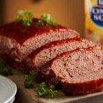 uicy sliced Lipton meatloaf recipe with caramelized glaze, garnished with fresh parsley on wooden board