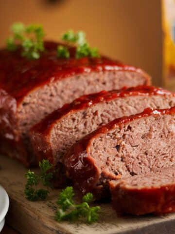 uicy sliced Lipton meatloaf recipe with caramelized glaze, garnished with fresh parsley on wooden board