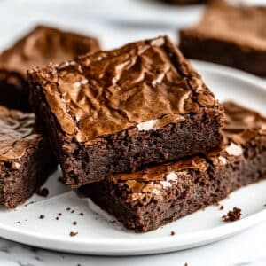Crackly-topped air fryer brownies with fudgy centers and crumbly edges. Real homemade feel on a white counter with natural light.