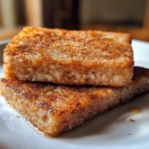 Crispy pan-fried scrapple slices on a plate, golden and ready for breakfast.