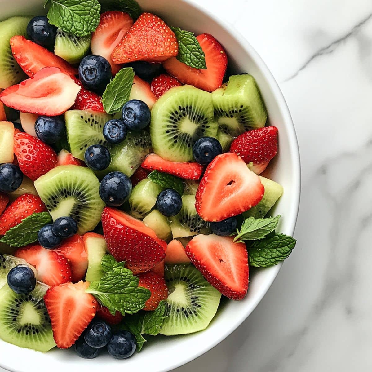 All fruits gently combined in one bowl for fruit salad base. Fresh pineapple, grapes, melon, and berries shine with natural juiciness.