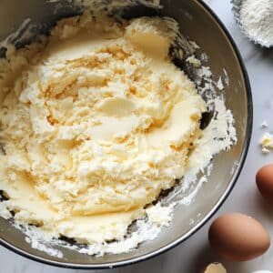 Creamed butter and sugar in a mixing bowl for lemon pound cake. Real kitchen setup with soft natural light and casual prep scene.
