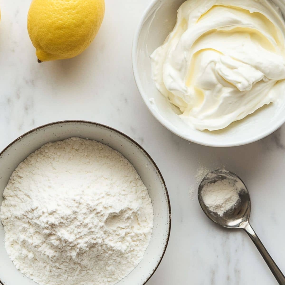 Two bowls for lemon pound cake mixing: one with dry flour mix, one with tangy lemon-sour cream mixture. Casual kitchen shot.