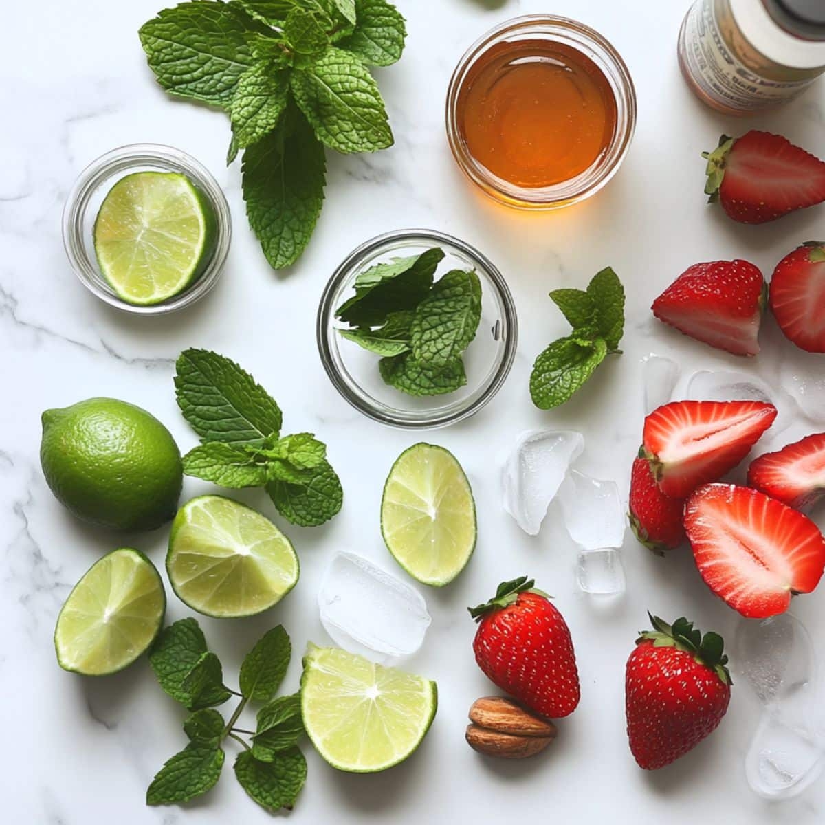 Strawberry mojito ingredients including fresh strawberries, mint, lime, honey, and white rum on a kitchen counter.