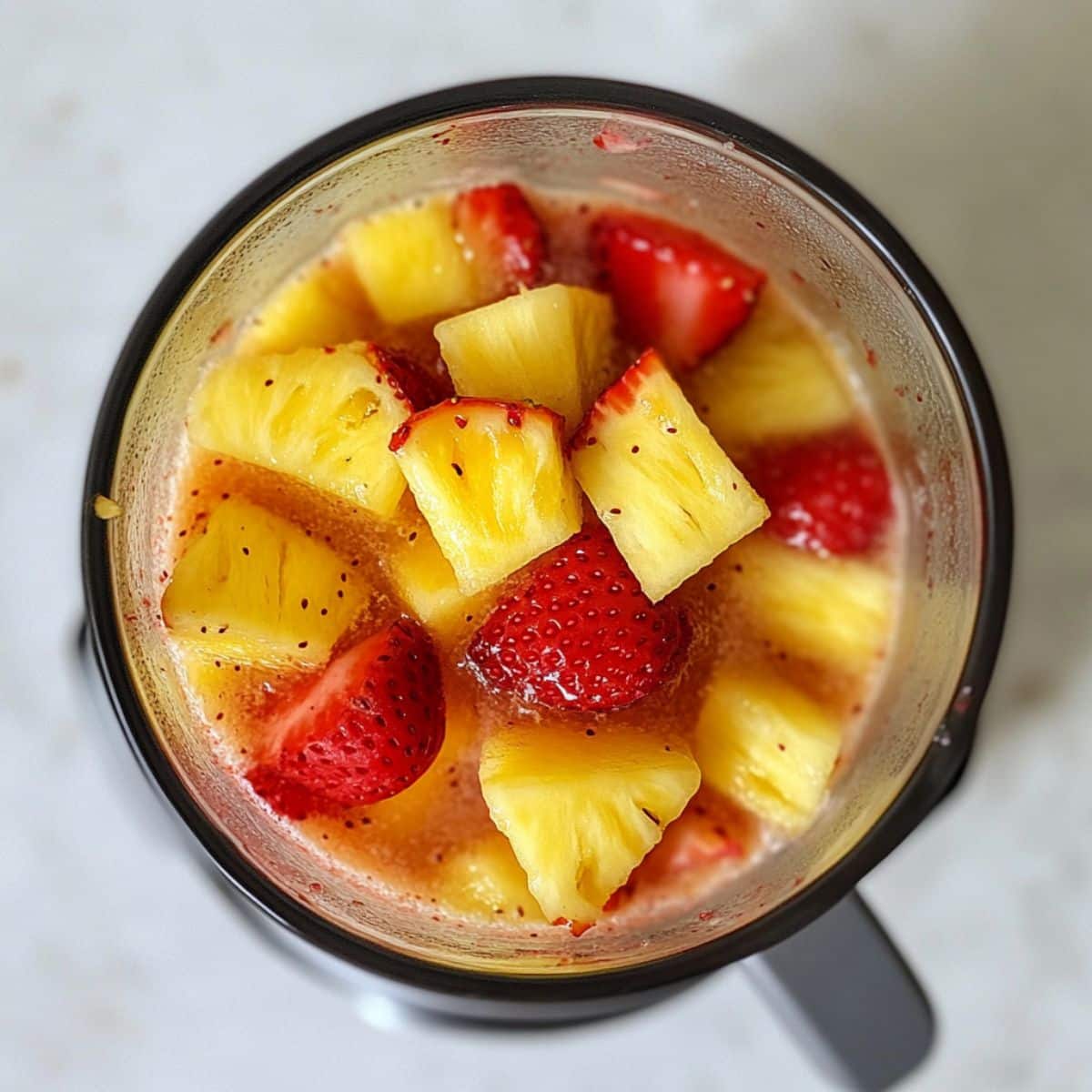 Fruit and water blending in a homemade kitchen for agua fresca. Bright and messy, real-life food prep.