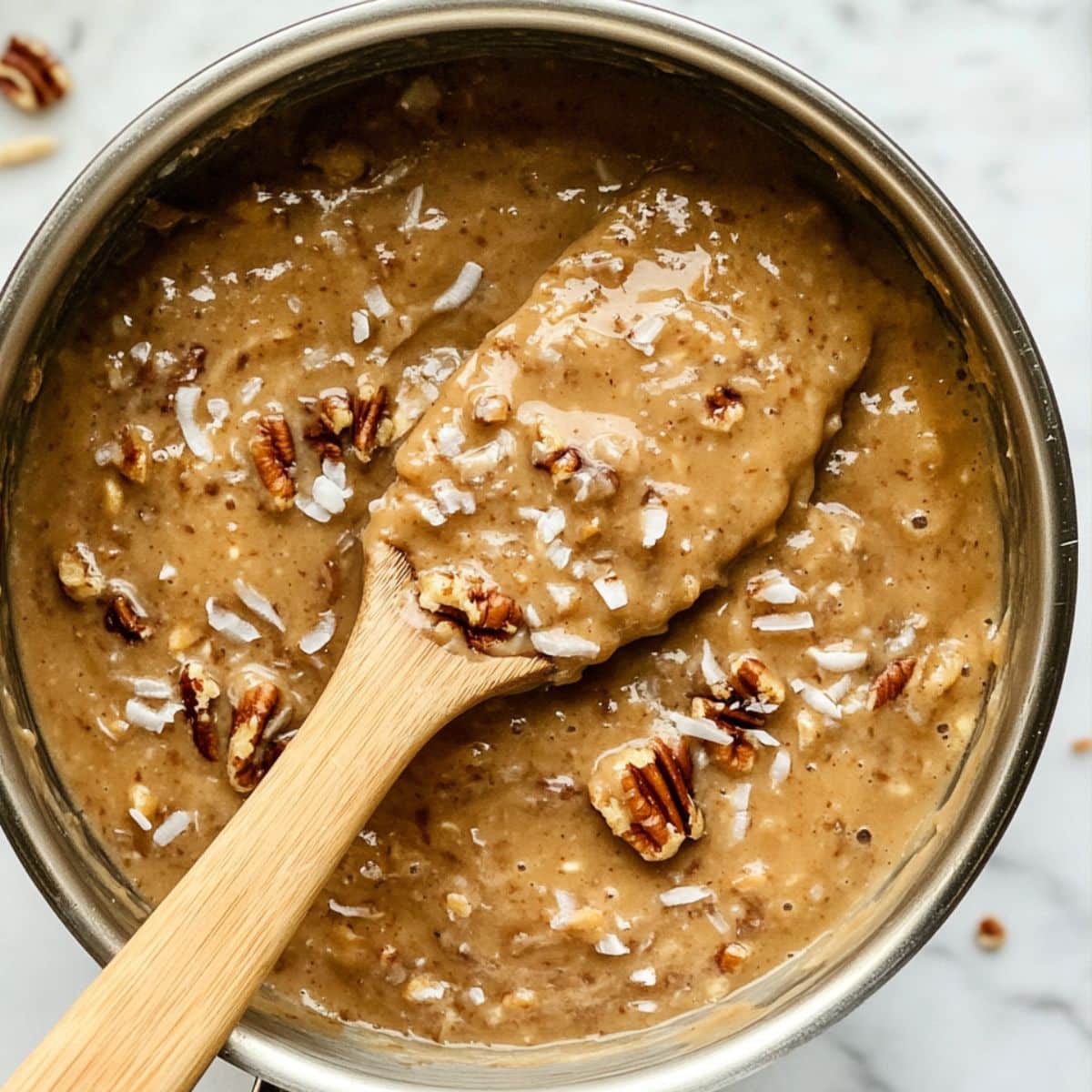 Smooth caramel coconut pecan frosting with rich texture ready to cool and spread.