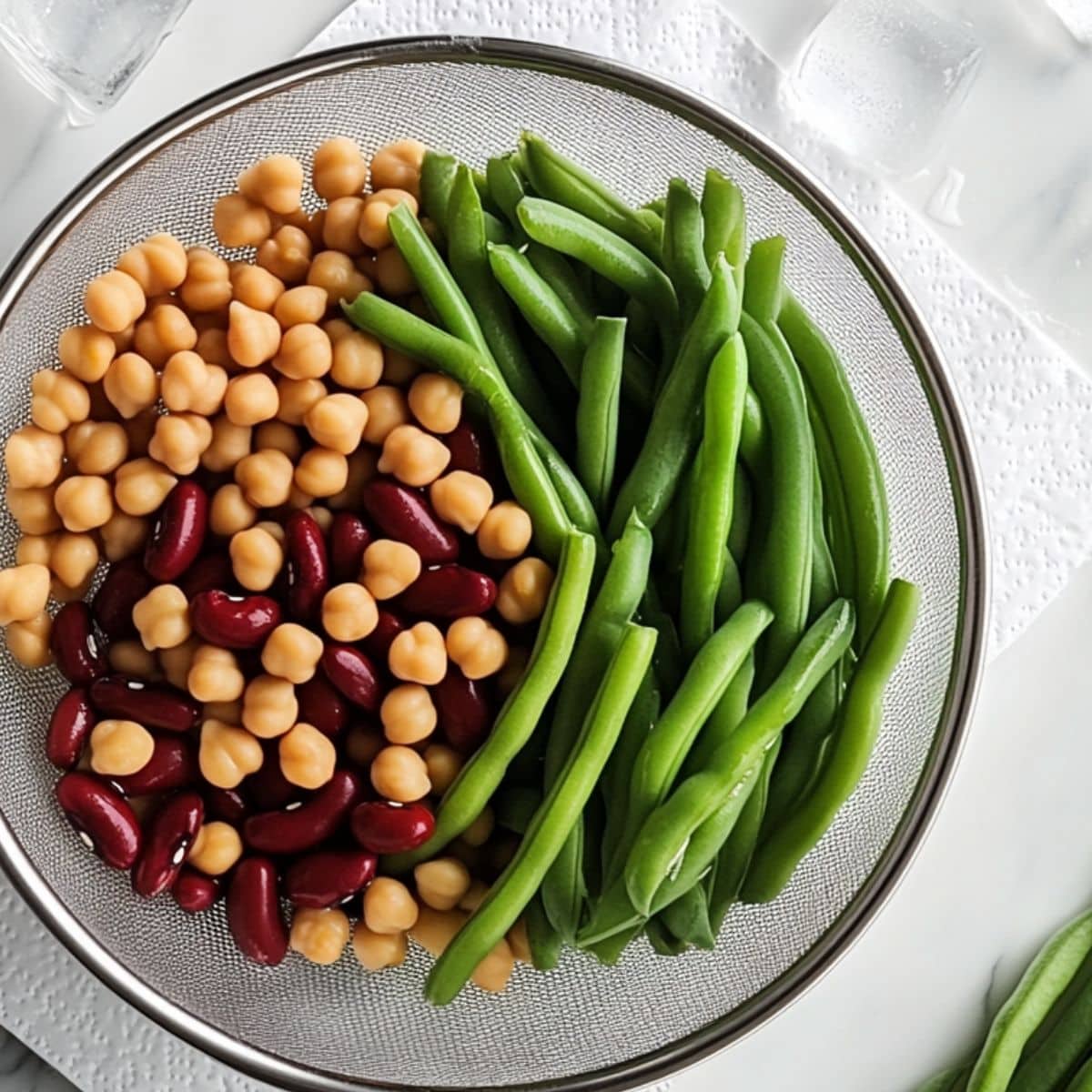 Freshly blanched green beans and rinsed canned beans drying on paper towels.