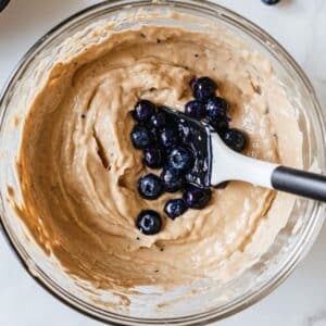 Blueberries folded gently into waffle batter before cooking. Final step to juicy, golden homemade waffles.