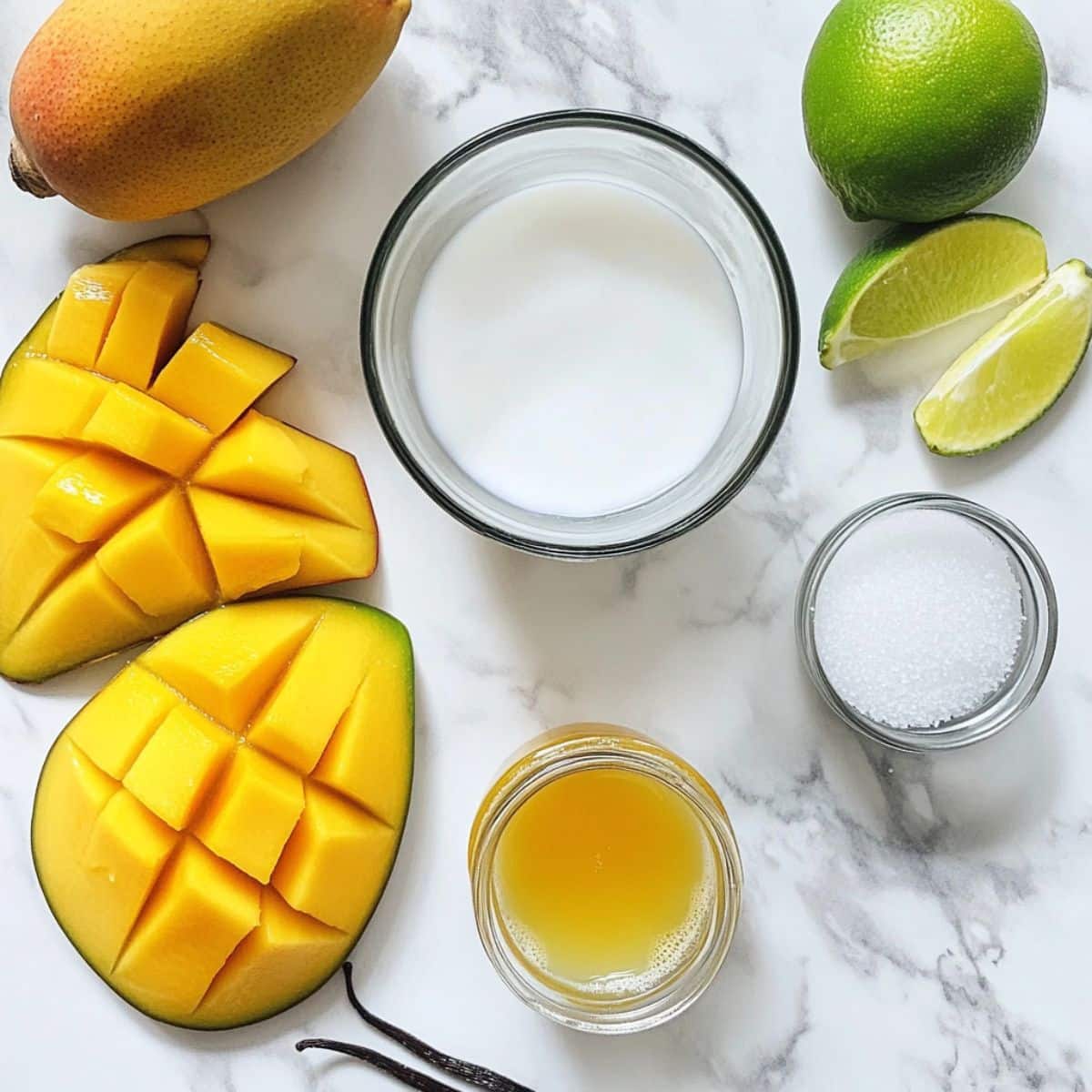 All mango sorbet ingredients on a white counter: mangoes, lime, honey, and vanilla. Natural and homemade kitchen scene.