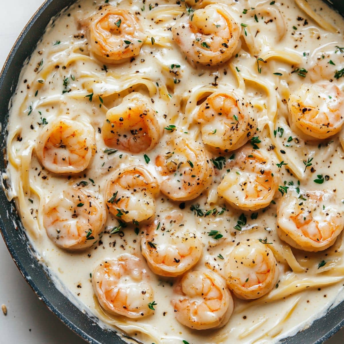 Creamy shrimp pasta tossed with herbs and sauce. Real skillet shot showing final homemade result.