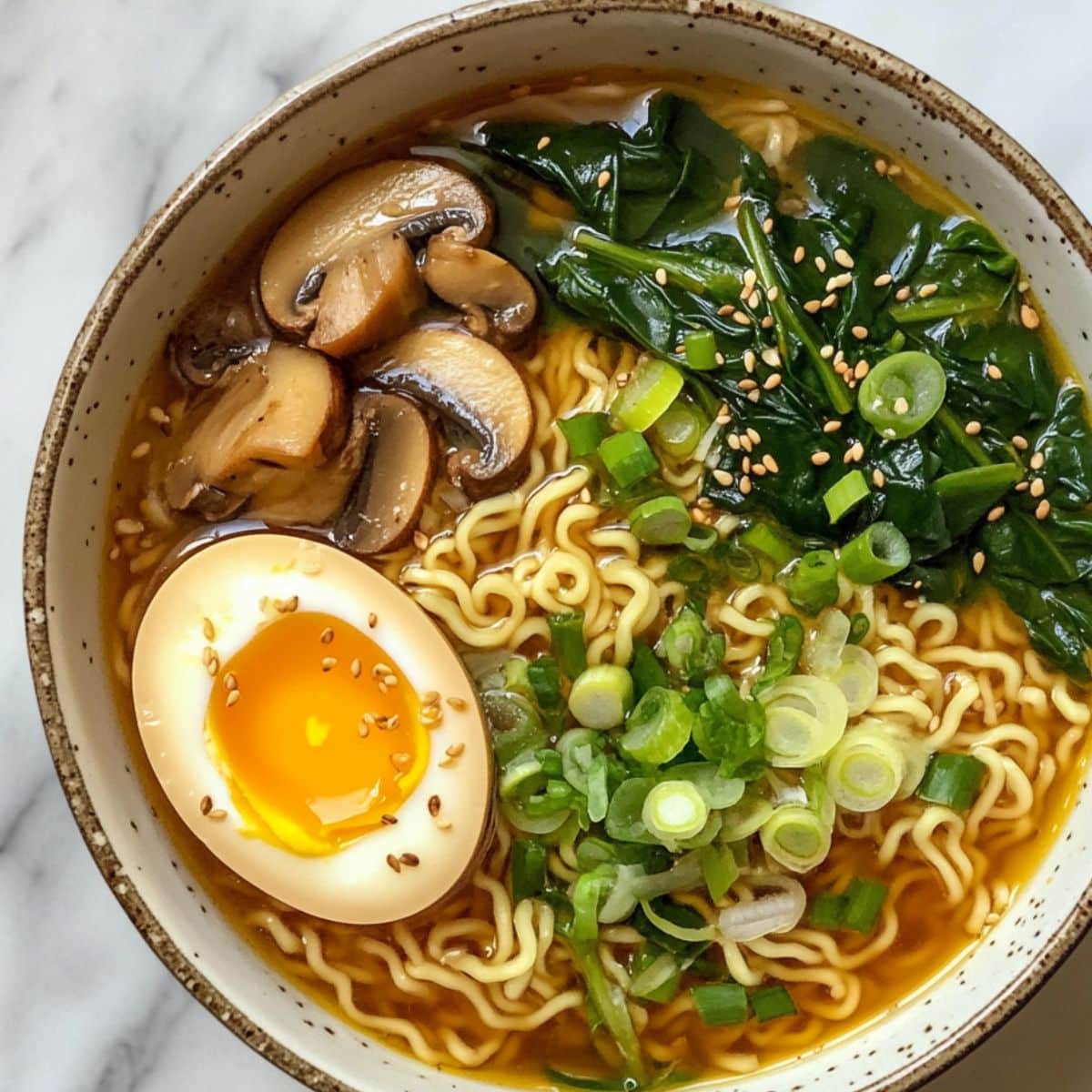 Close-up of steaming homemade ramen noodles on white marble counter. Soft egg, rich broth.