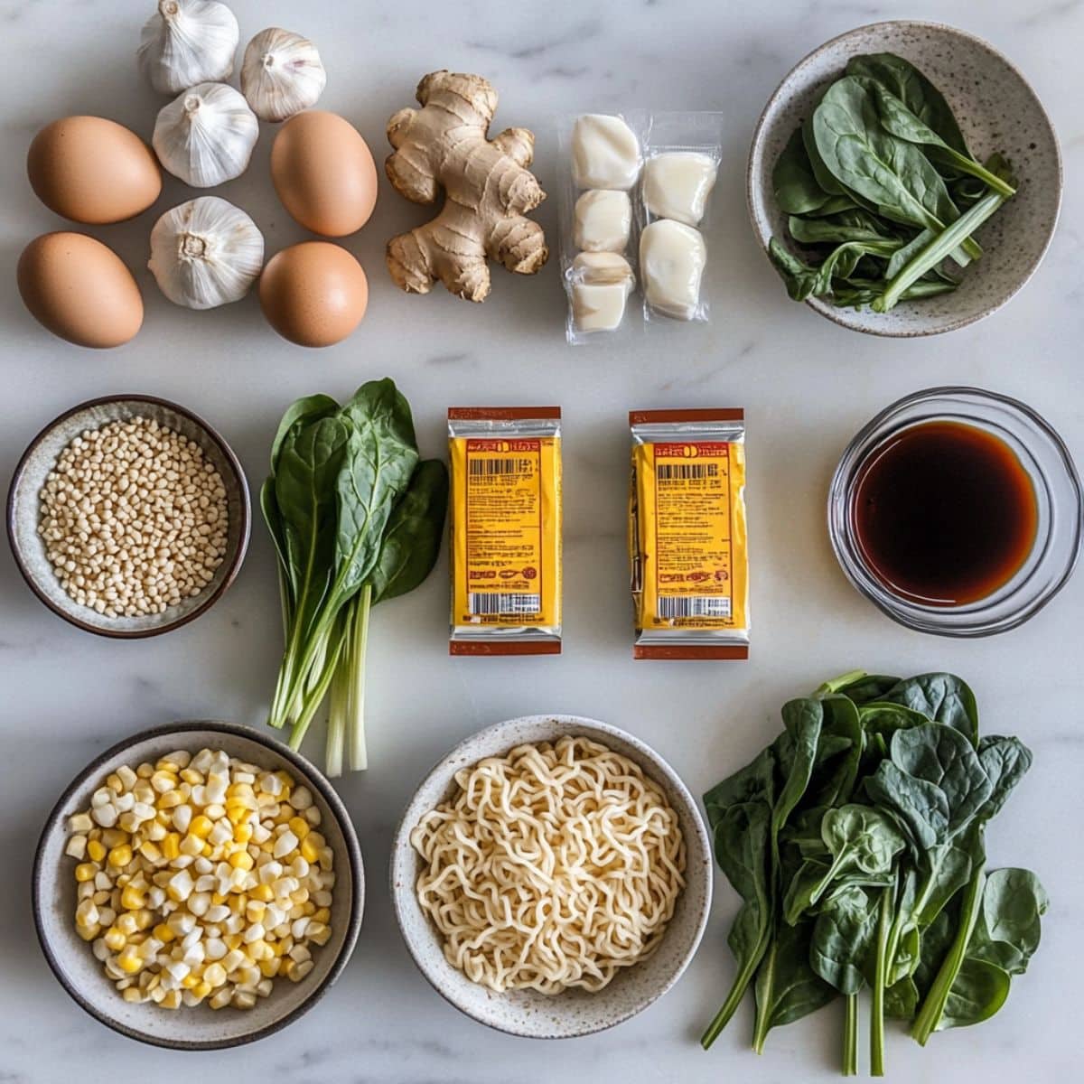 All ingredients for ramen noodles displayed casually on a white kitchen counter. Includes broth, noodles, aromatics, and toppings.