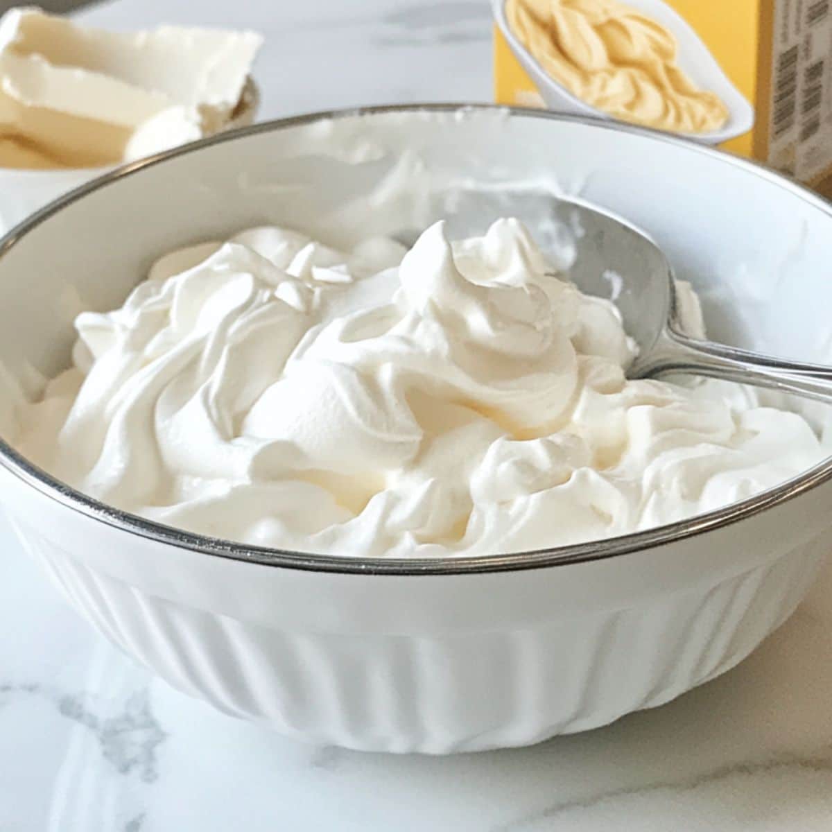 Homemade whipped cream mixed with vanilla pudding in a bowl. Creamy filling for peach trifle.