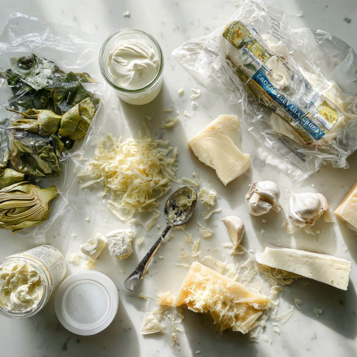 Fresh ingredients for homemade spinach artichoke dip including cream cheese and frozen spinach.