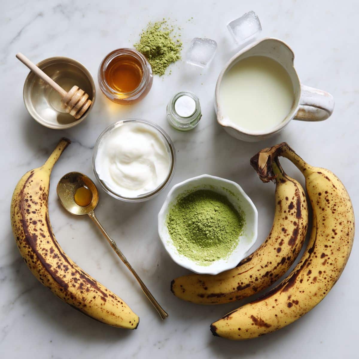 Fresh ingredients for banana matcha smoothie including ripe bananas and ceremonial matcha powder.