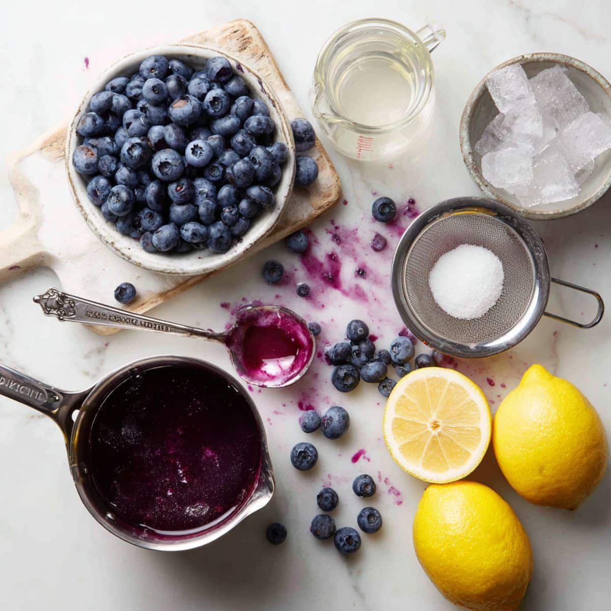 Fresh ingredients for homemade blueberry lemonade including ripe blueberries and juicy lemons.