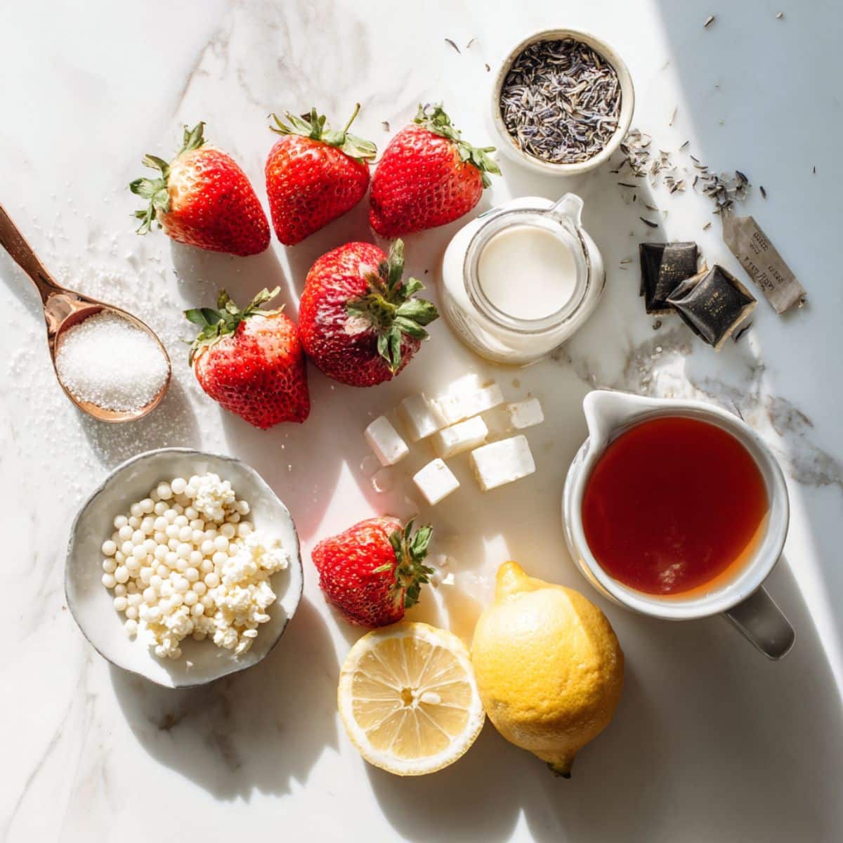 Fresh strawberry milk tea ingredients including real strawberries, black tea, and milk on counter. Simple bubble tea ingredients for homemade strawberry drink recipe.