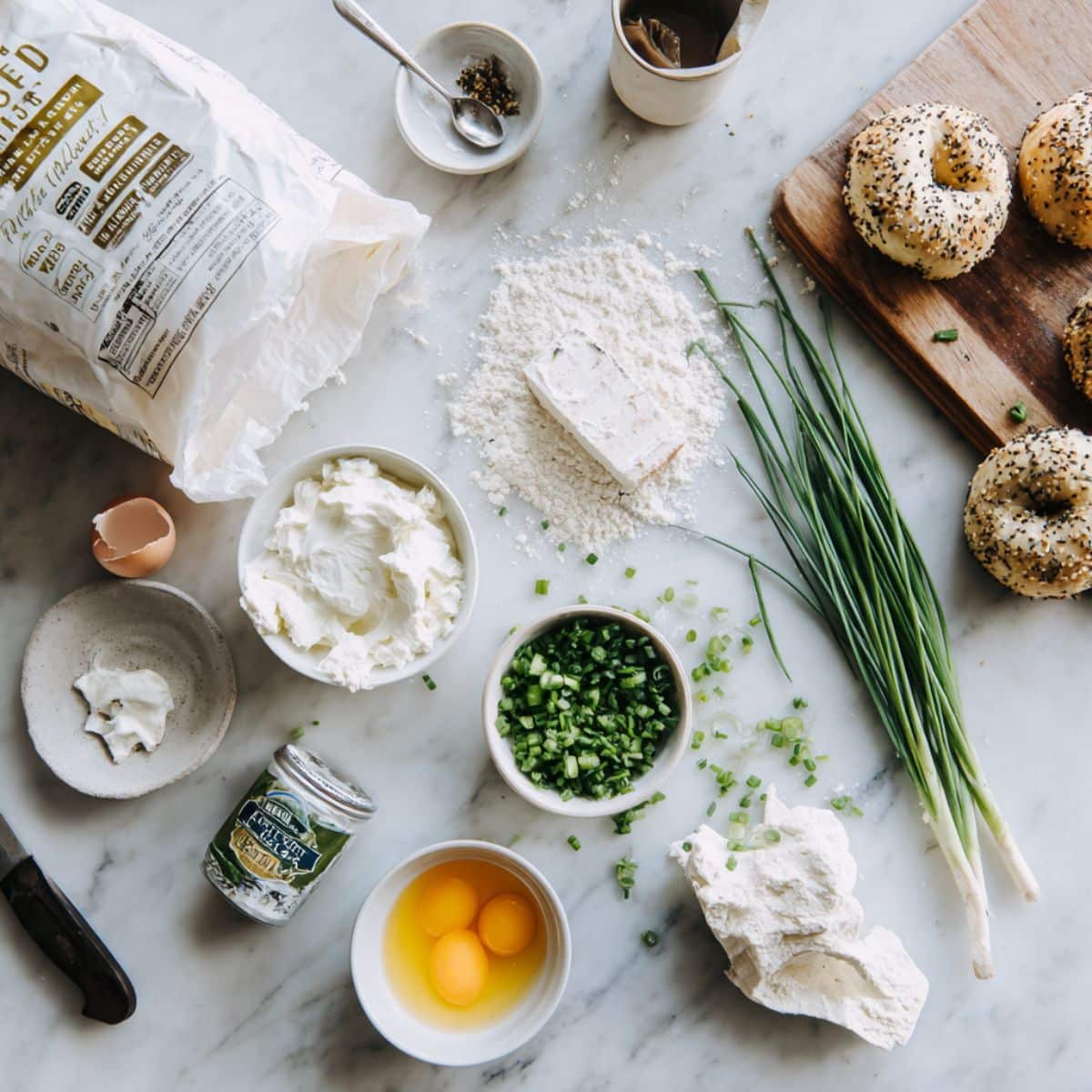 Simple ingredients for homemade stuffed bagel bites including flour, yogurt, and cream cheese.