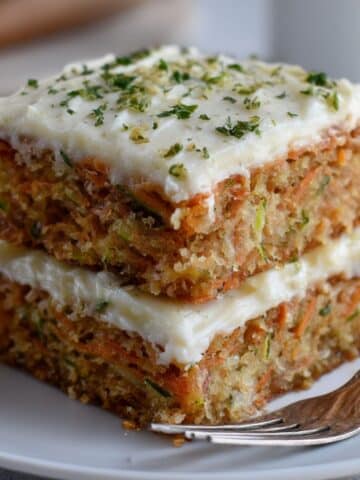 Moist carrot zucchini cake with cream cheese frosting, homemade layered cake with fresh shredded carrots, zucchini, and creamy frosting topping.