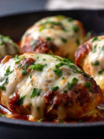 Juicy mozzarella chicken breasts smothered in golden, bubbly melted mozzarella, topped with fresh parsley and nestled in rich tomato sauce.