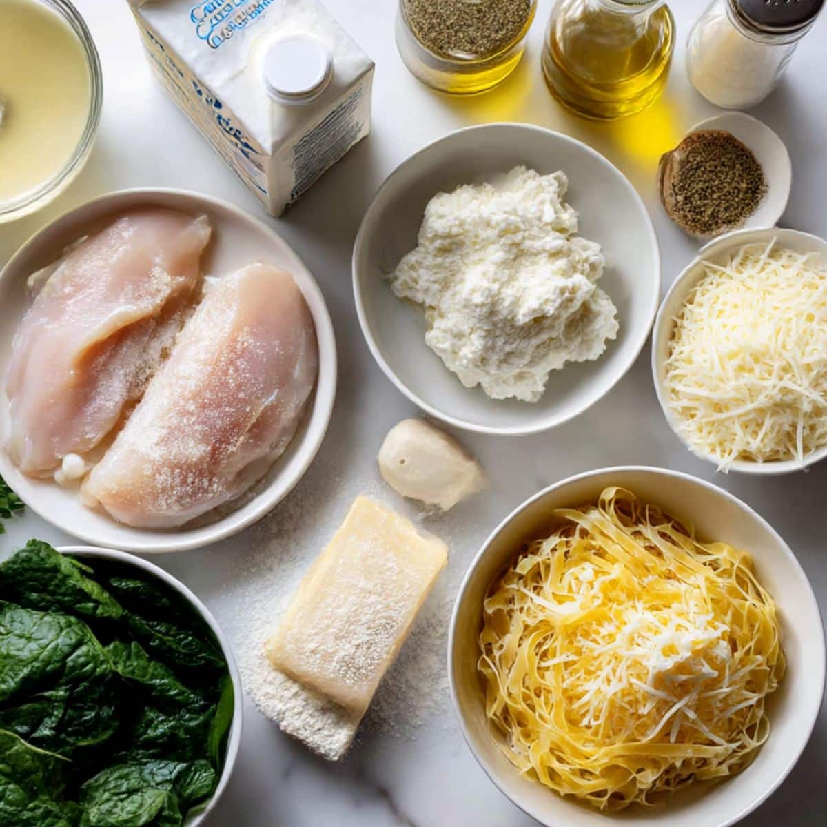 Ingredients for white lasagna soup including chicken, cream, three cheeses, and pasta noodles