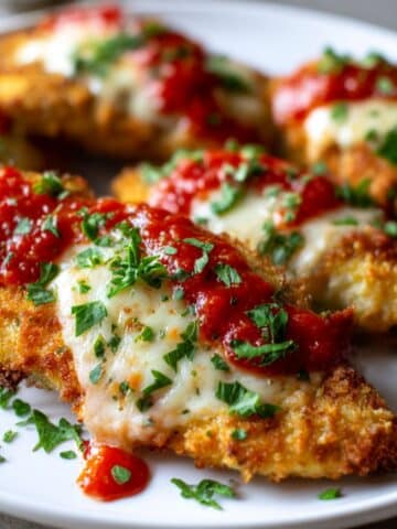 Crispy air fryer chicken parmesan topped with marinara, melted cheese, and fresh parsley.