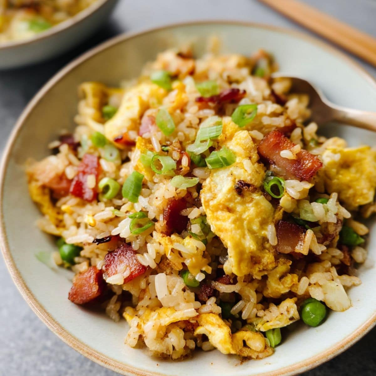 Homemade breakfast fried rice with crispy bacon, scrambled eggs, and green onions.