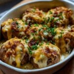 Cheesy Mississippi Mud Potatoes baked with crispy bacon, melted cheddar, and creamy ranch sauce, topped with fresh chives.