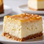 Golden gooey Neiman Marcus cake square with buttery crust and creamy center on a white plate.