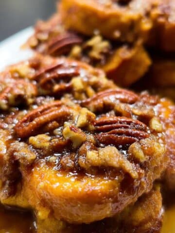 Golden overnight pecan pie french toast topped with caramelized pecans and sticky brown sugar syrup.