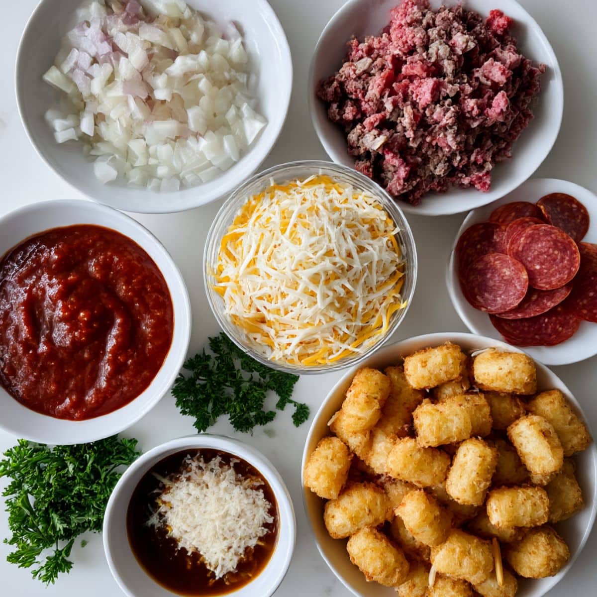 Overhead photo of tater tots, cheese, pepperoni, ground beef, and pizza sauce ingredients for homemade pizza tater tot casserole.