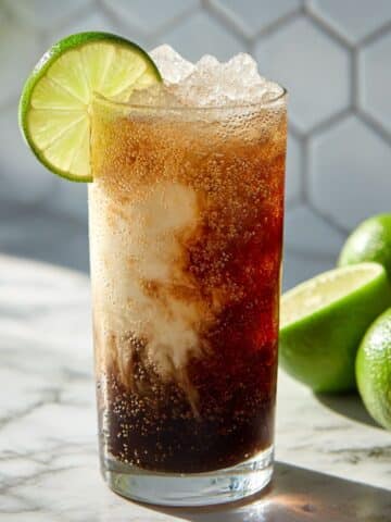 Homemade Sonic dirty soda with creamy coconut swirls, ice, and a lime slice on top.