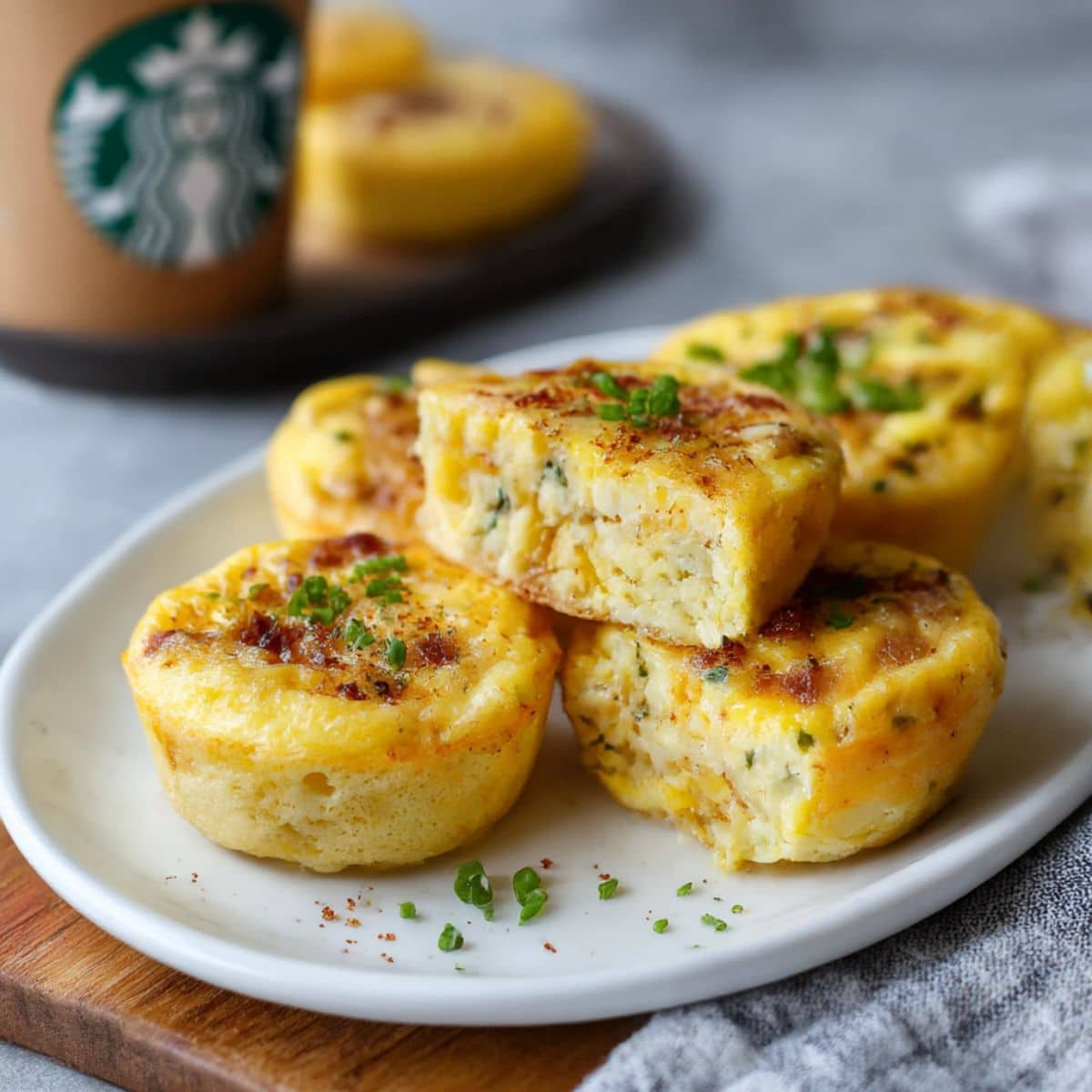 Fluffy copycat Starbucks egg bites with bacon and Gruyere cheese stacked on white plate, easy homemade high protein breakfast recipe