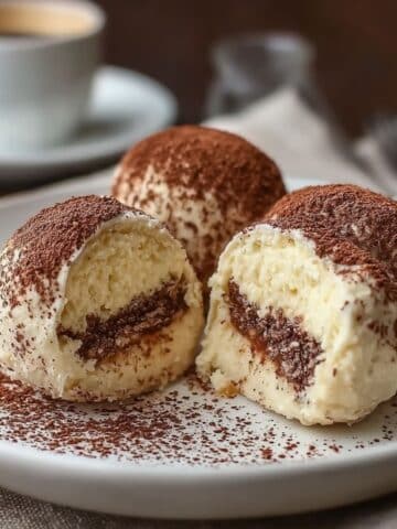 Creamy tiramisu truffles coated in cocoa powder with espresso layers inside.
