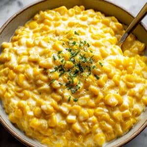Creamy homemade creamed corn topped with fresh herbs in a rustic bowl.