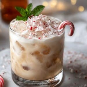 Peppermint white russian topped with crushed candy canes and ice, garnished with a mini candy cane and fresh mint.