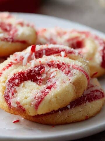Festive peppermint swirl cookies with red and white candy cane spirals topped with crushed peppermint.