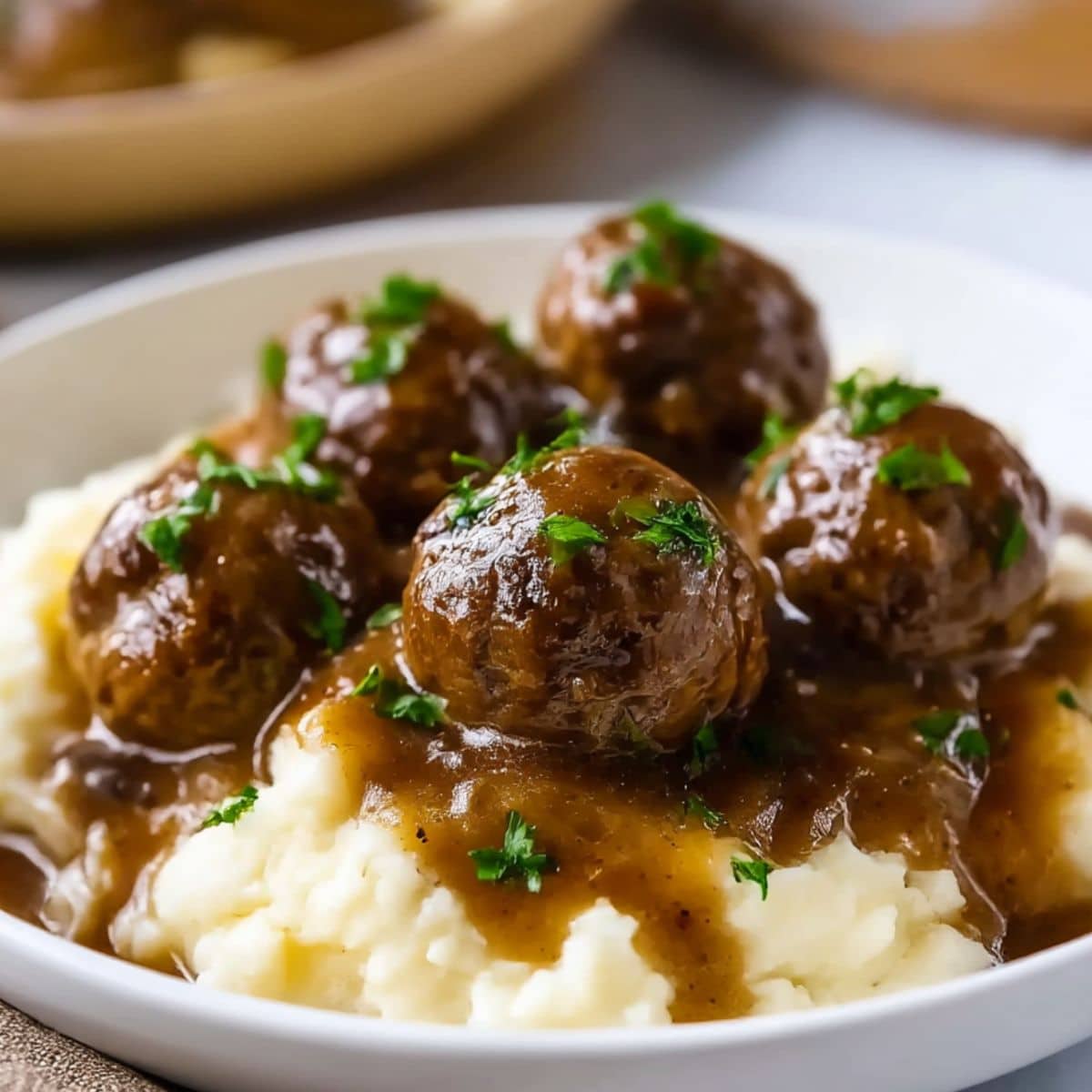 Homemade Salisbury steak meatballs served over creamy mashed potatoes with rich brown gravy.