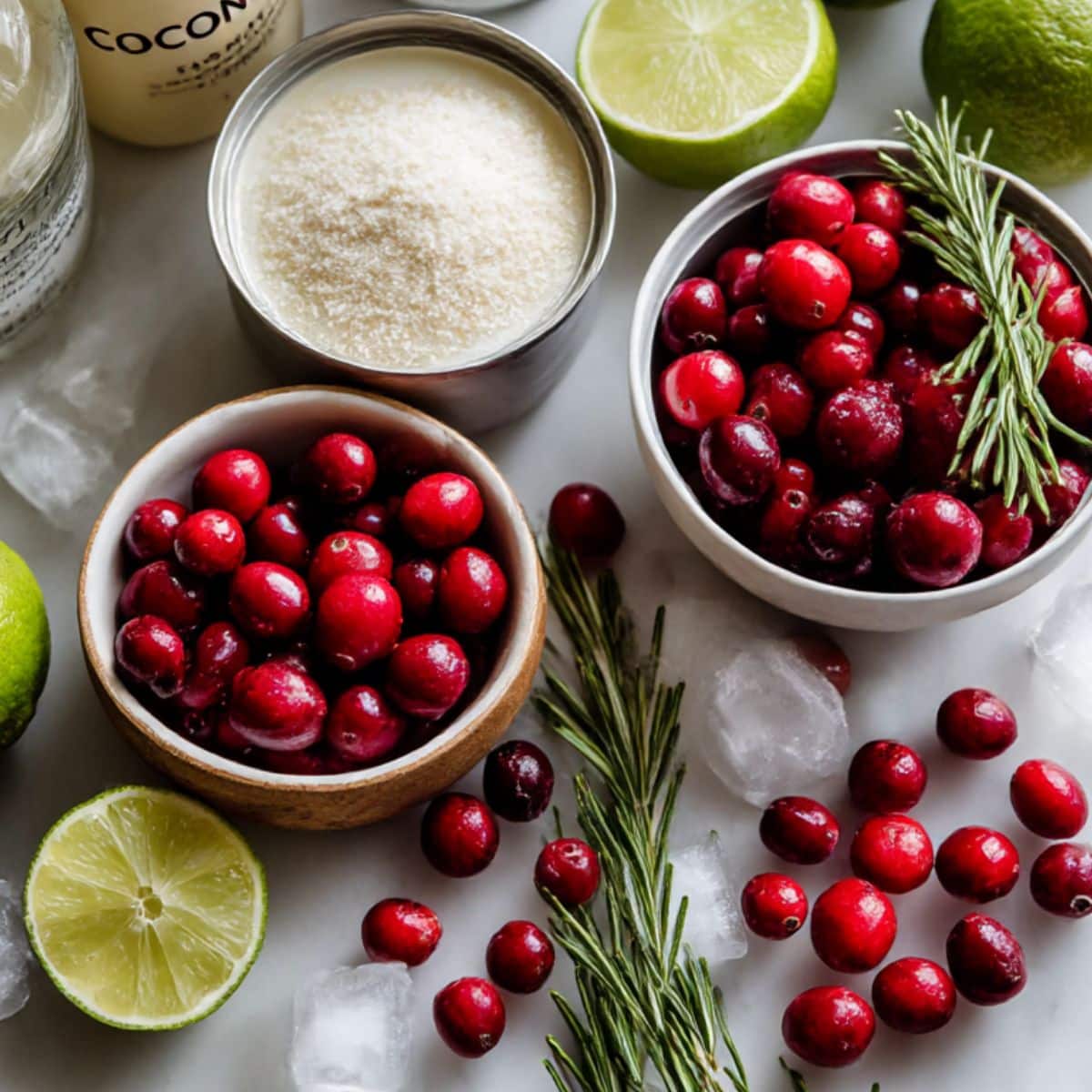 Overhead view of white Christmas cranberry margarita ingredients on a white kitchen counter.