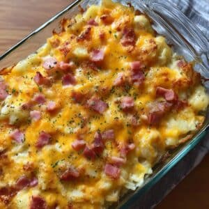 Golden baked cheesy ham potato casserole topped with melted cheddar and diced ham.