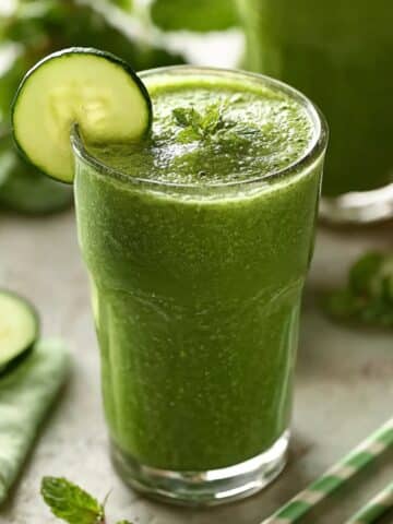 Fresh cucumber smoothie made with blended cucumber and mint in a clear glass