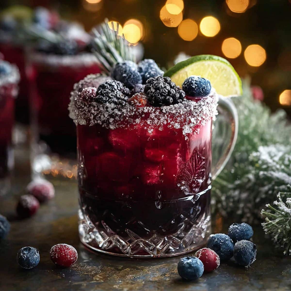 Midnight Frost Christmas Punch served in a sugar-rimmed glass with dark berry punch, frozen berries, and citrus garnish for a festive holiday drink.