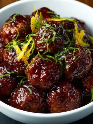 Slow cooker teriyaki meatballs glazed in a sticky sauce and garnished with citrus zest and herbs