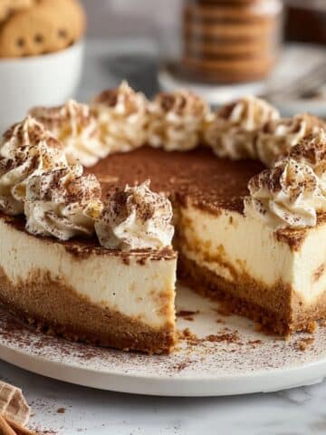 Snickerdoodle cheesecake with cinnamon-spiced filling, whipped cream swirls, and a buttery cookie crust