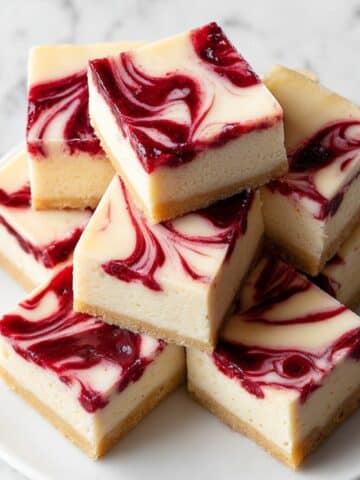 White chocolate raspberry fudge squares with creamy layers and raspberry swirl