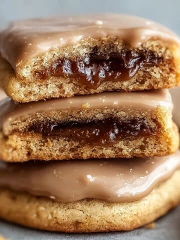 Brown sugar pop tart cookies with cinnamon filling and smooth vanilla glaze stacked to show soft centers