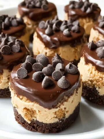 Chocolate chip cookie dough brownie bites with a fudgy brownie base, creamy cookie dough center, and glossy chocolate topping sprinkled with mini chocolate chips.